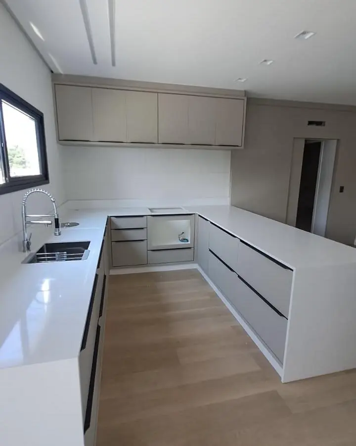 Cozinha em U com bancada clara entregue pela Bella Mármores